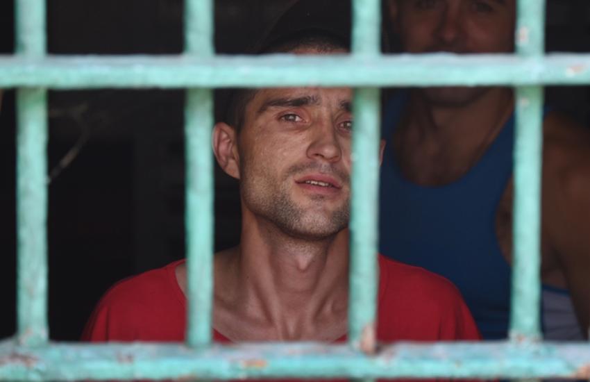 Un détenu cherche la lumière à travers les barreaux de sa cellule à Kiev, 
en Ukraine. © AFP / Sergei Supinsky

