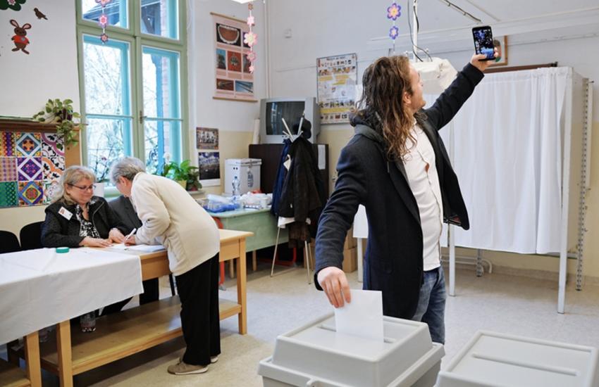 Un électeur dans un bureau de vote de Budapest (Hongrie), se prend en photo 
au moment de déposer son bulletin de vote. © Sputnik

