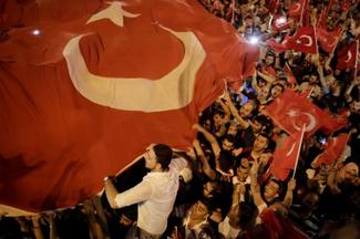 People hold Turkish flags in Taksim square in Istanbul on July 16, 2016 during a demonstration in support to Turkish president. 