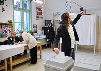 Un électeur dans un bureau de vote de Budapest (Hongrie), se prend en photo 
au moment de déposer son bulletin de vote. © Sputnik

